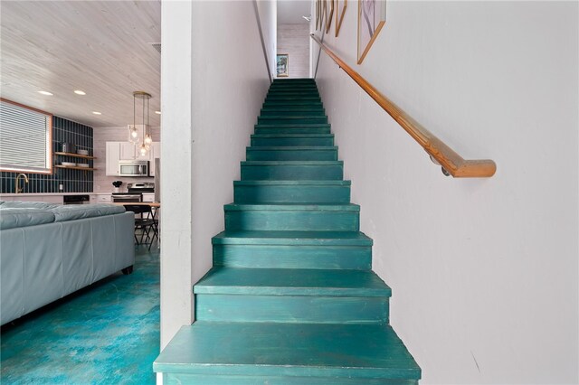 stairs with concrete floors and sink