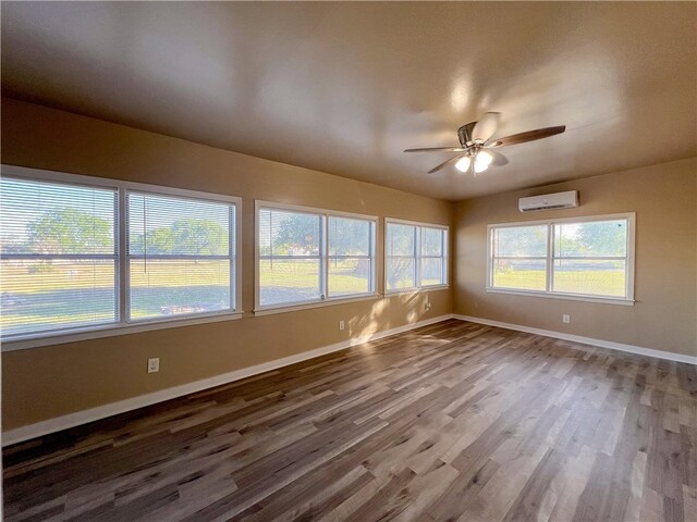 unfurnished sunroom with a wall unit AC and ceiling fan