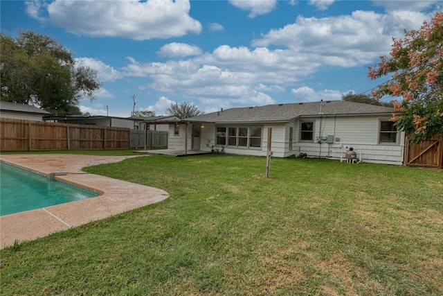 rear view of house featuring a fenced in pool, a yard, and a patio