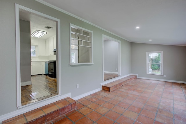 tiled spare room featuring vaulted ceiling, built in features, and ornamental molding