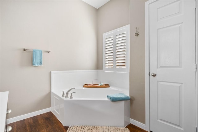 bathroom featuring wood-type flooring and a tub to relax in