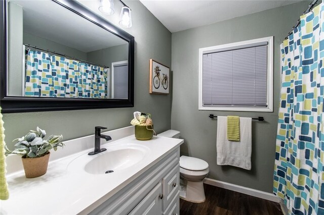 950 Susan Dr, Corpus Christi, TX 78412 - bathroom with toilet, wood finished floors, vanity, baseboards, and curtained shower