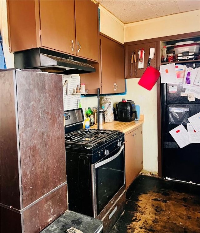 kitchen featuring black refrigerator and stainless steel gas stove