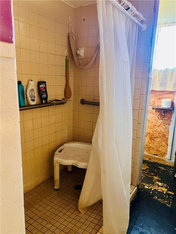 bathroom with curtained shower and tile walls