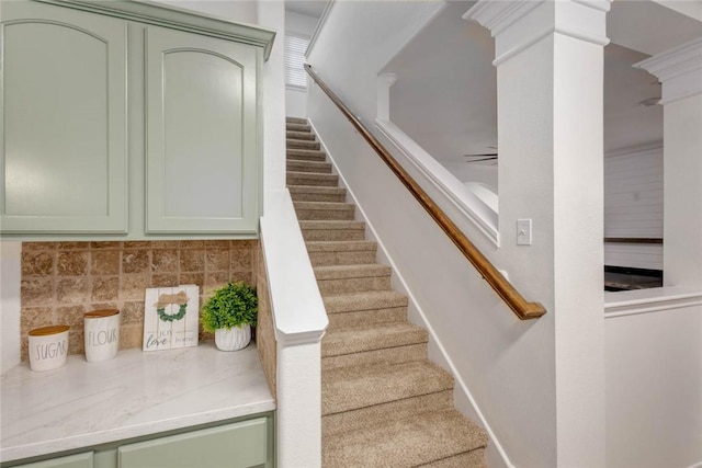 staircase featuring ceiling fan and ornate columns