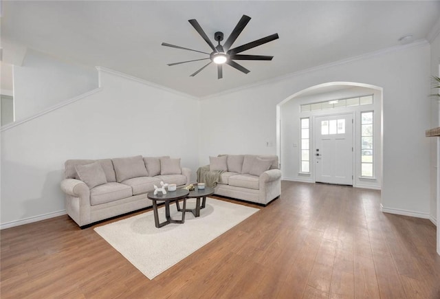 living room featuring light wood-type flooring, ceiling fan, and ornamental molding