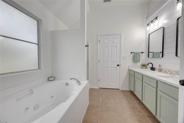 bathroom with tile patterned floors, vanity, and a tub to relax in