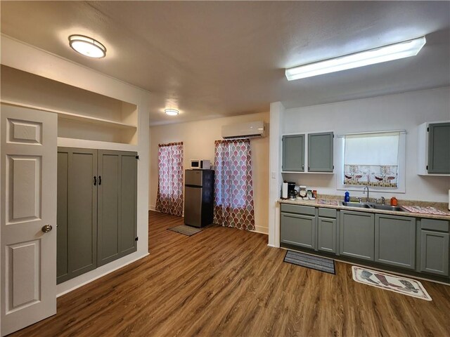 1613 6th St, Corpus Christi, TX 78404 - kitchen featuring freestanding refrigerator, a sink, a wall mounted air conditioner, and gray cabinetry