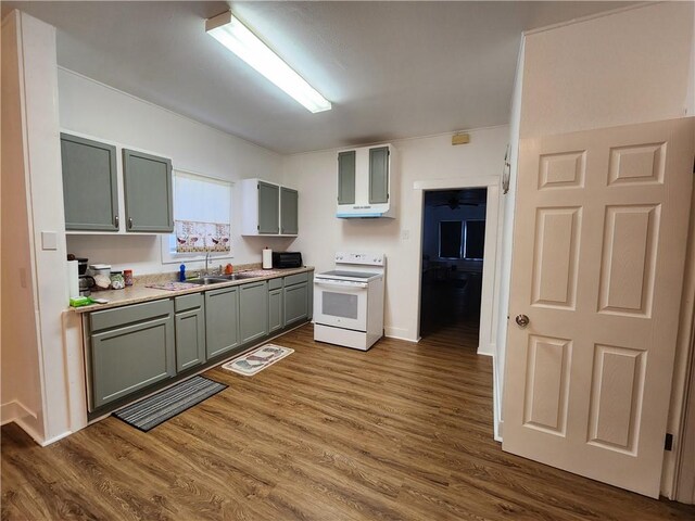 1613 6th St, Corpus Christi, TX 78404 - kitchen with white range with electric stovetop, gray cabinetry, wall chimney exhaust hood, light countertops, and dark wood-style flooring