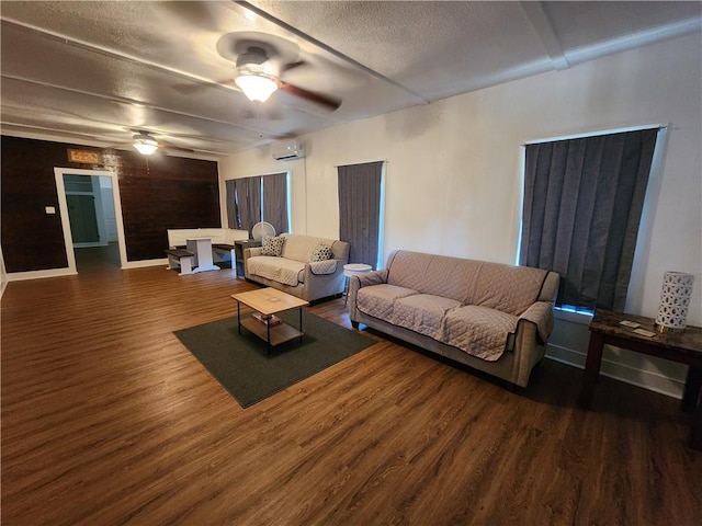 1613 6th St, Corpus Christi, TX 78404 - living room featuring ceiling fan, a wall mounted AC, wood finished floors, a textured ceiling, and baseboards