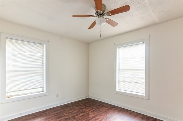 unfurnished room featuring dark hardwood / wood-style flooring, ceiling fan, and plenty of natural light