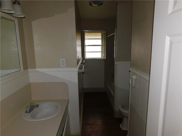 bathroom with toilet, a shower, vanity, and hardwood / wood-style flooring