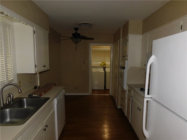 kitchen with separate washer and dryer, white cabinetry, sink, dark wood-type flooring, and white appliances
