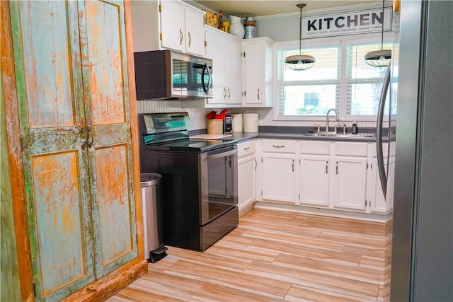 1508 Roosevelt Dr, Alice, TX 78332 - kitchen featuring stainless steel appliances, white cabinetry, crown molding, light wood finished floors, and dark countertops