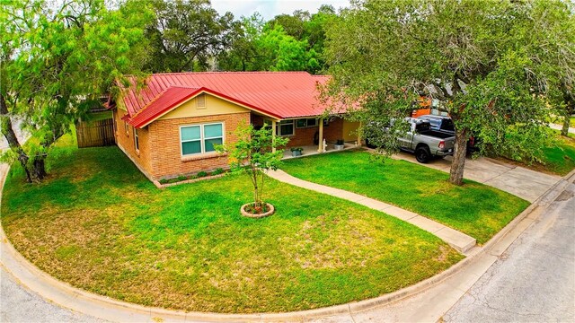 1508 Roosevelt Dr, Alice, TX 78332 - single story home with a metal roof, a front lawn, brick siding, and driveway
