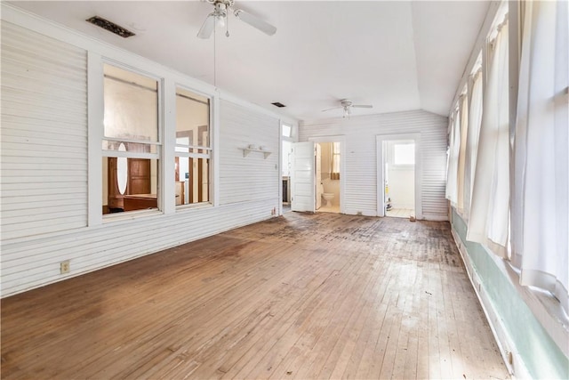 interior space featuring hardwood / wood-style floors, lofted ceiling, a ceiling fan, and visible vents
