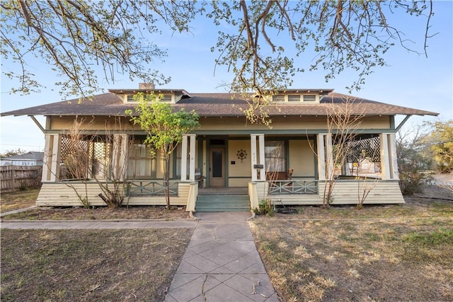 view of front of property featuring covered porch and a shingled roof