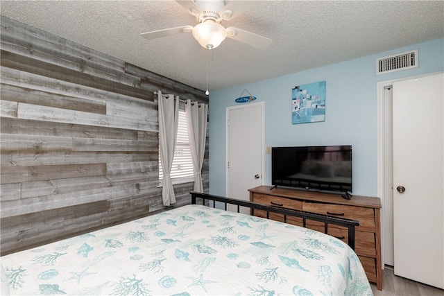 bedroom featuring ceiling fan, a textured ceiling, and light hardwood / wood-style flooring