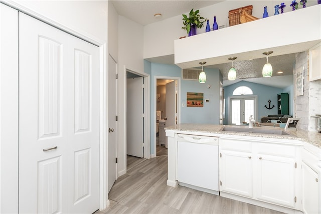 kitchen with light wood-type flooring, decorative light fixtures, sink, white cabinets, and dishwasher