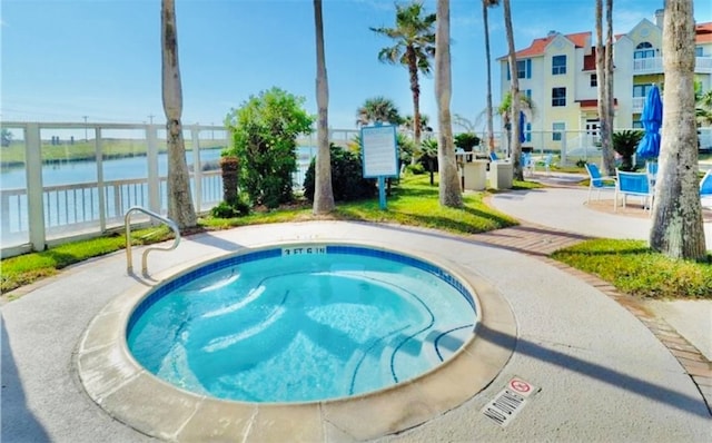 view of pool with a community hot tub and a water view