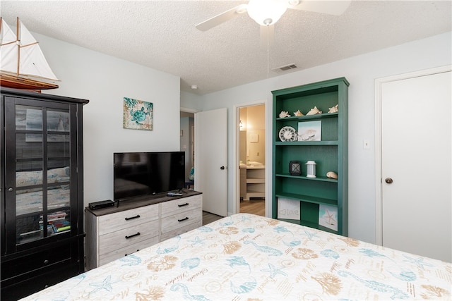 bedroom featuring a textured ceiling, ceiling fan, and ensuite bathroom