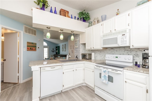 kitchen featuring white cabinetry, kitchen peninsula, and white appliances