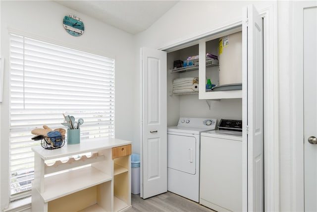 clothes washing area featuring separate washer and dryer and light hardwood / wood-style flooring