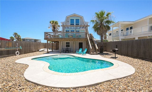 view of swimming pool featuring a patio area, a fenced backyard, stairway, and a wooden deck