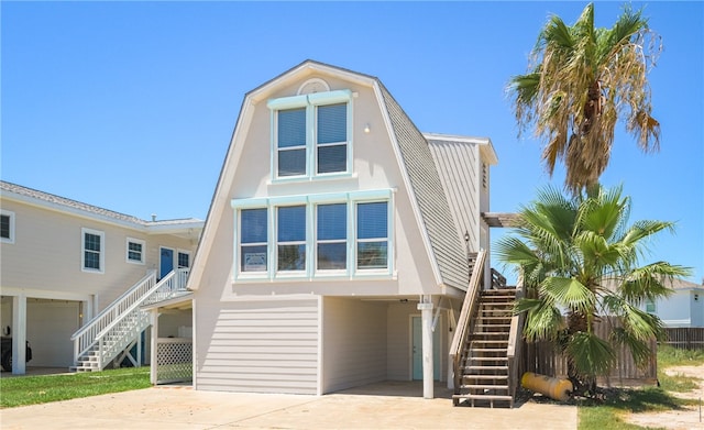 view of front facade featuring driveway, stairs, and a carport