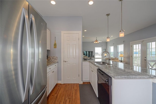 kitchen with freestanding refrigerator, a sink, white cabinets, dishwasher, and open floor plan