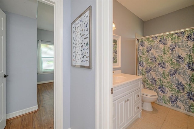 full bath featuring tile patterned flooring, baseboards, toilet, a shower with shower curtain, and vanity