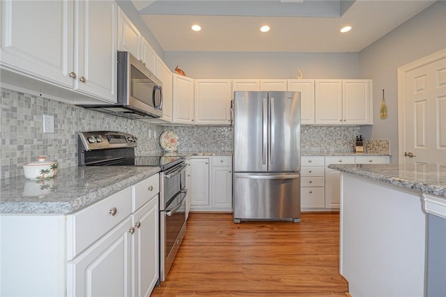 kitchen with light stone counters, decorative backsplash, light wood-style flooring, appliances with stainless steel finishes, and white cabinets