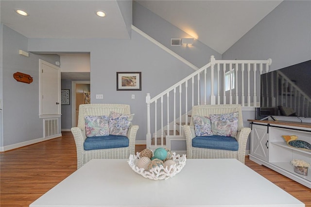 sitting room featuring visible vents, stairway, and wood finished floors