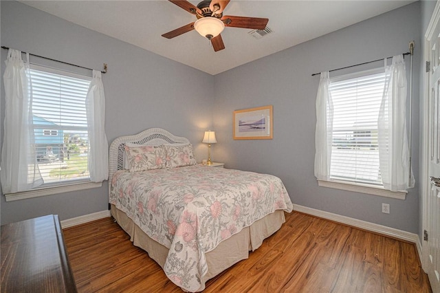 bedroom with light wood-style flooring, baseboards, visible vents, and ceiling fan