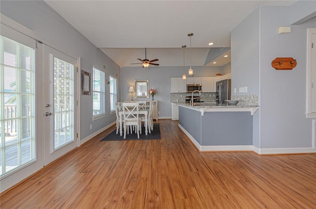 unfurnished dining area featuring light wood-type flooring, a ceiling fan, a sink, french doors, and baseboards