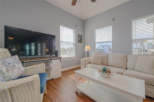 living room with light wood finished floors, baseboards, ceiling fan, and vaulted ceiling