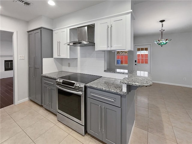 kitchen featuring wall chimney exhaust hood, a peninsula, stainless steel electric range, a kitchen bar, and white cabinetry