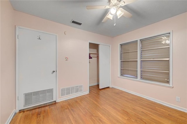 unfurnished bedroom featuring ceiling fan, a closet, and light wood-type flooring