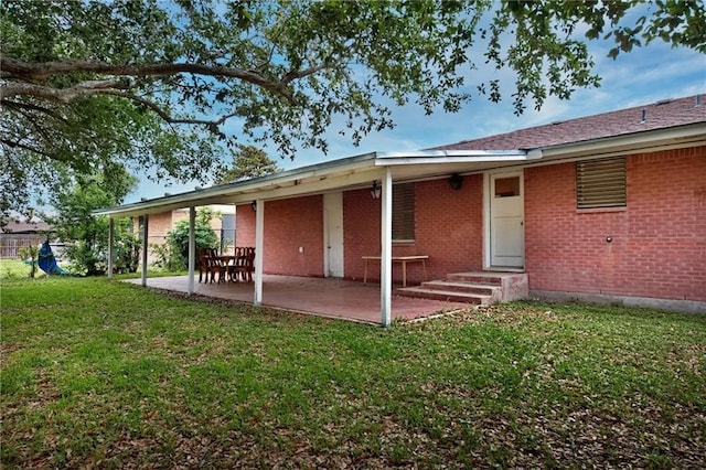 rear view of property with a patio and a lawn