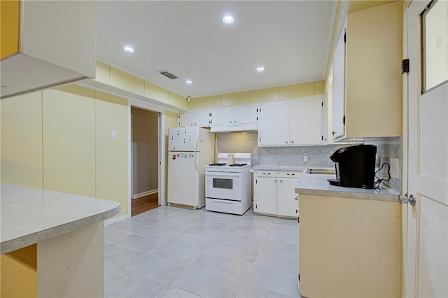 kitchen featuring white appliances, white cabinetry, light tile patterned flooring, and tasteful backsplash