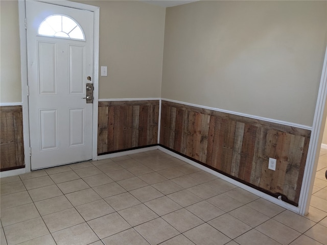 tiled entryway with wood walls