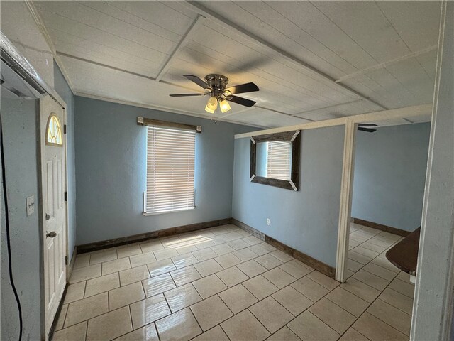 tiled spare room with ceiling fan