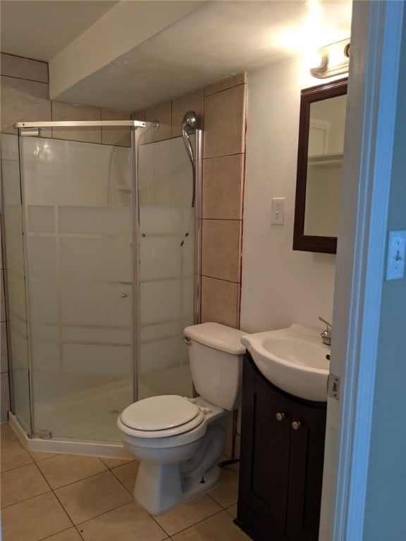 bathroom featuring tile patterned floors, vanity, toilet, and walk in shower