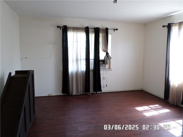 spare room with plenty of natural light and wood finished floors