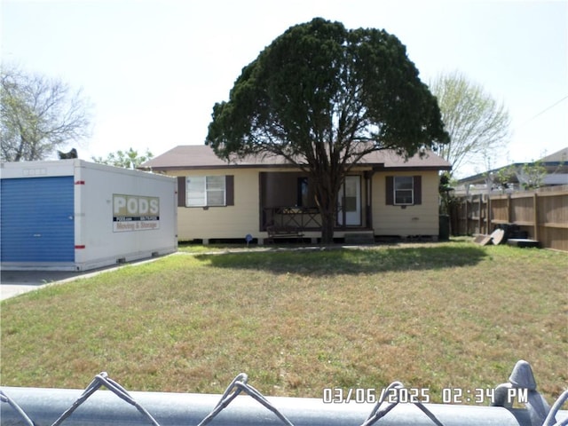 ranch-style home with a front yard and fence