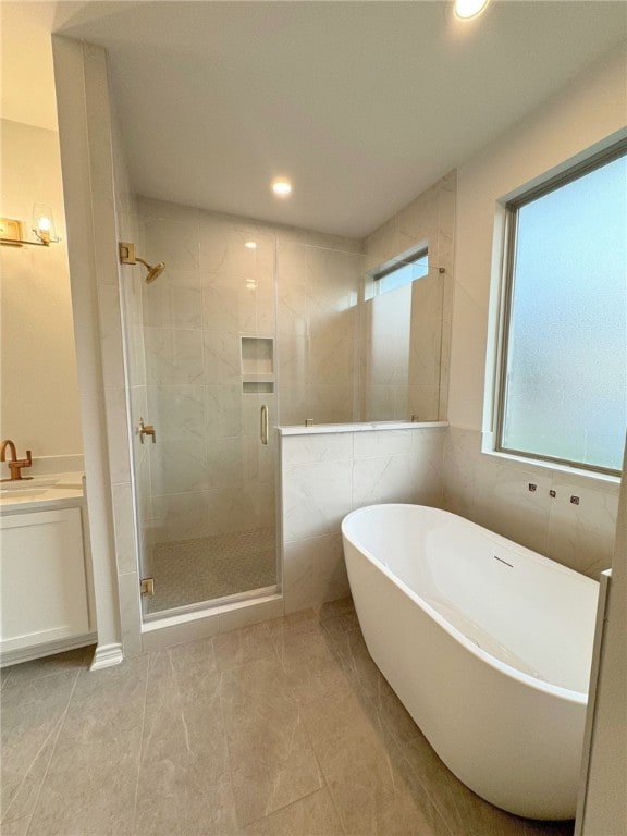 bathroom featuring vanity, tile patterned flooring, and plus walk in shower