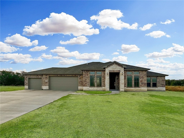 prairie-style home featuring a garage and a front lawn