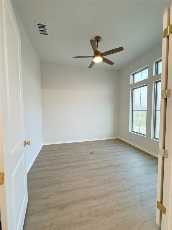 empty room featuring light wood-type flooring and ceiling fan