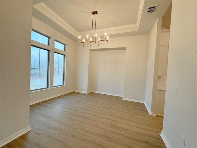 spare room with crown molding, light hardwood / wood-style flooring, and a chandelier