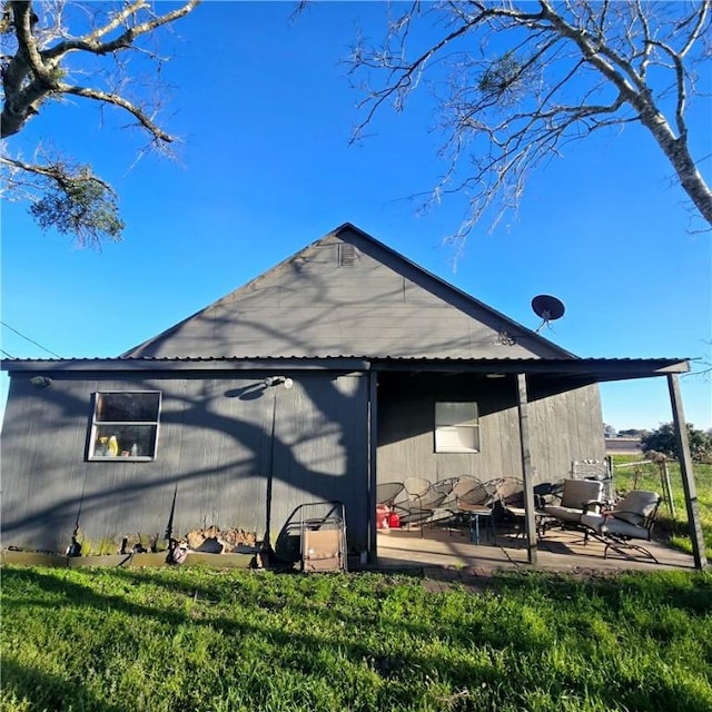 back of house featuring a lawn and a patio